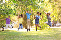 Kinder springen auf einer Wiese. Children playing together outdoors. Quelle: © New Africa / fotolia