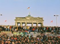 Menschen aus West- und Ost stehen auf der Mauerkrone am Brandenburger Tor am 10.11.1989, 2019. Quelle: © Bundesregierung / Klaus Lehnartz