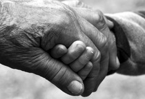 Hand einer betagten Person umfasst Hand eines kleinen Kindes. Quelle: © Pixabay