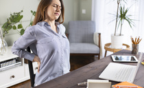 Freelancer young woman suffering with back pain. Source: © dragonstock/adobe.stock.com